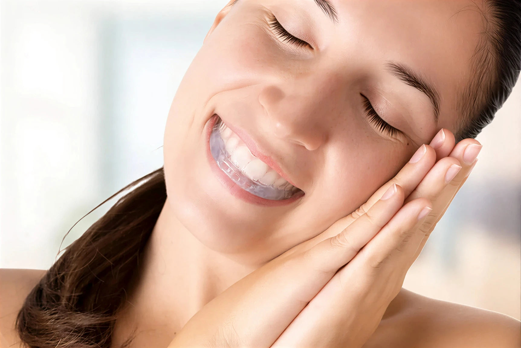 Woman with a clear dental retainer smiling against a blurred background